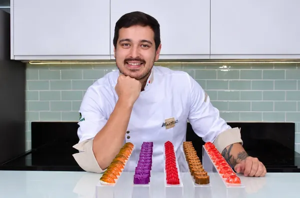 Gustavo Ono de dólmã branco com fileiras de bombons coloridos na bancada