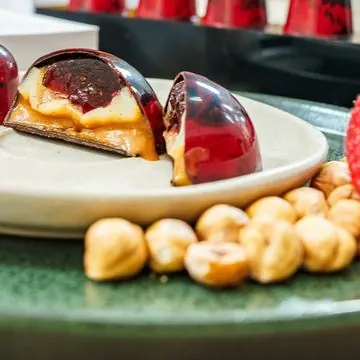 Bombom vermelho cortado com caramelo e avelãs
