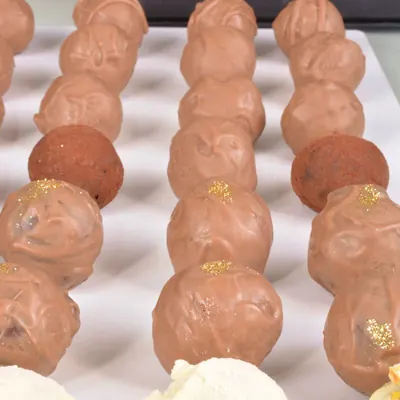 Fileiras de trufas ao leite com brilho dourado