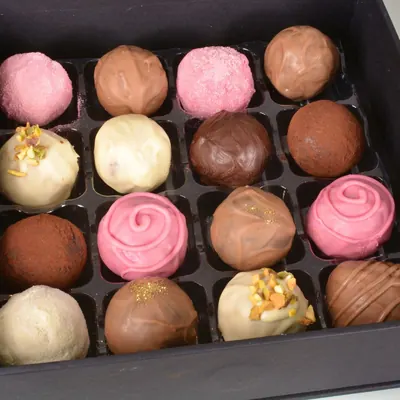 Caixa com 16 trufas recheadas de sabores variados: rosa, branca, ao leite, cacau e pistache