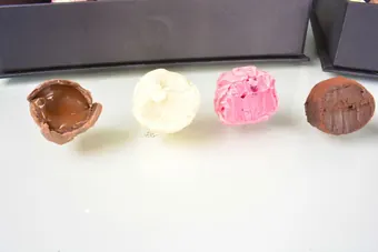 Trufas cortadas mostrando recheio de caramelo, baunilha e frutas vermelhas