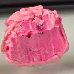 Trufa de frutas vermelhas cortada mostrando a massa rosa